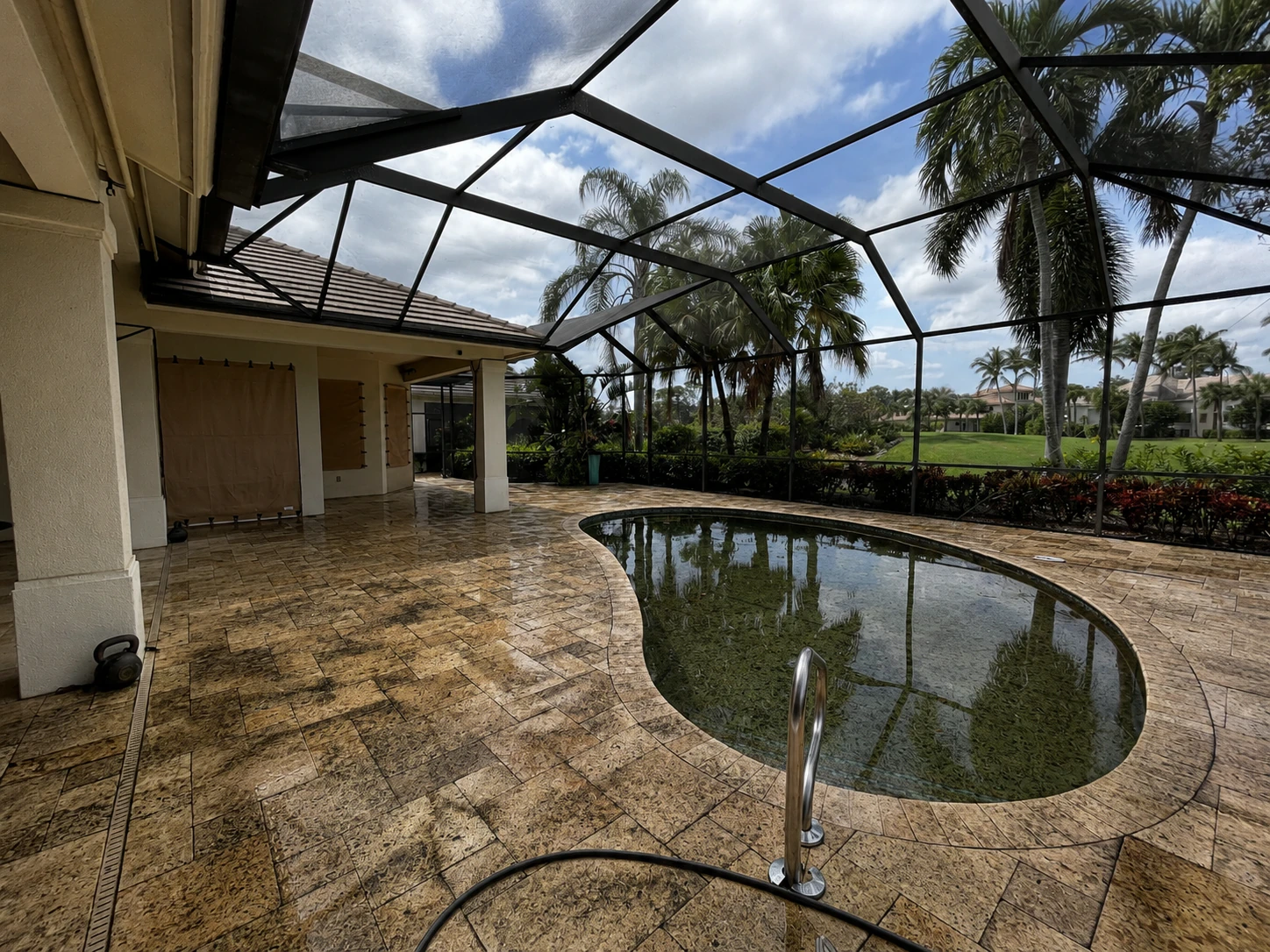 Pool deck before pressure washing, with dirt, algae, and mildew buildup